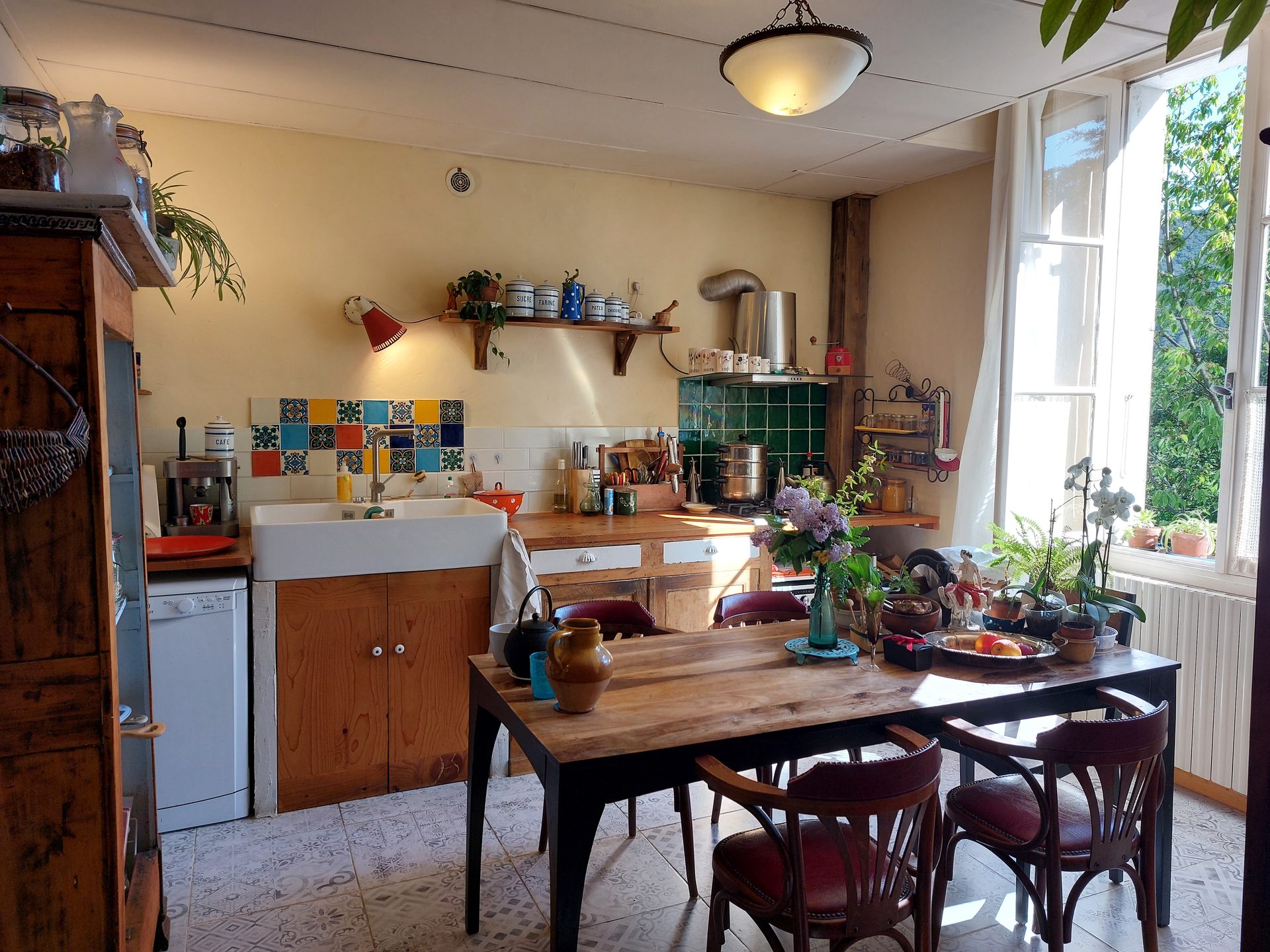 Cuisine avec évier en faïence, plan de travail bois et mosaïques au mur
