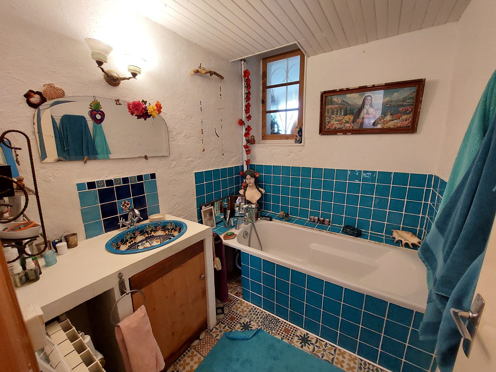 Salle de bain avec faïences bleues, vasque mexicaine et baignoire pleine longueur