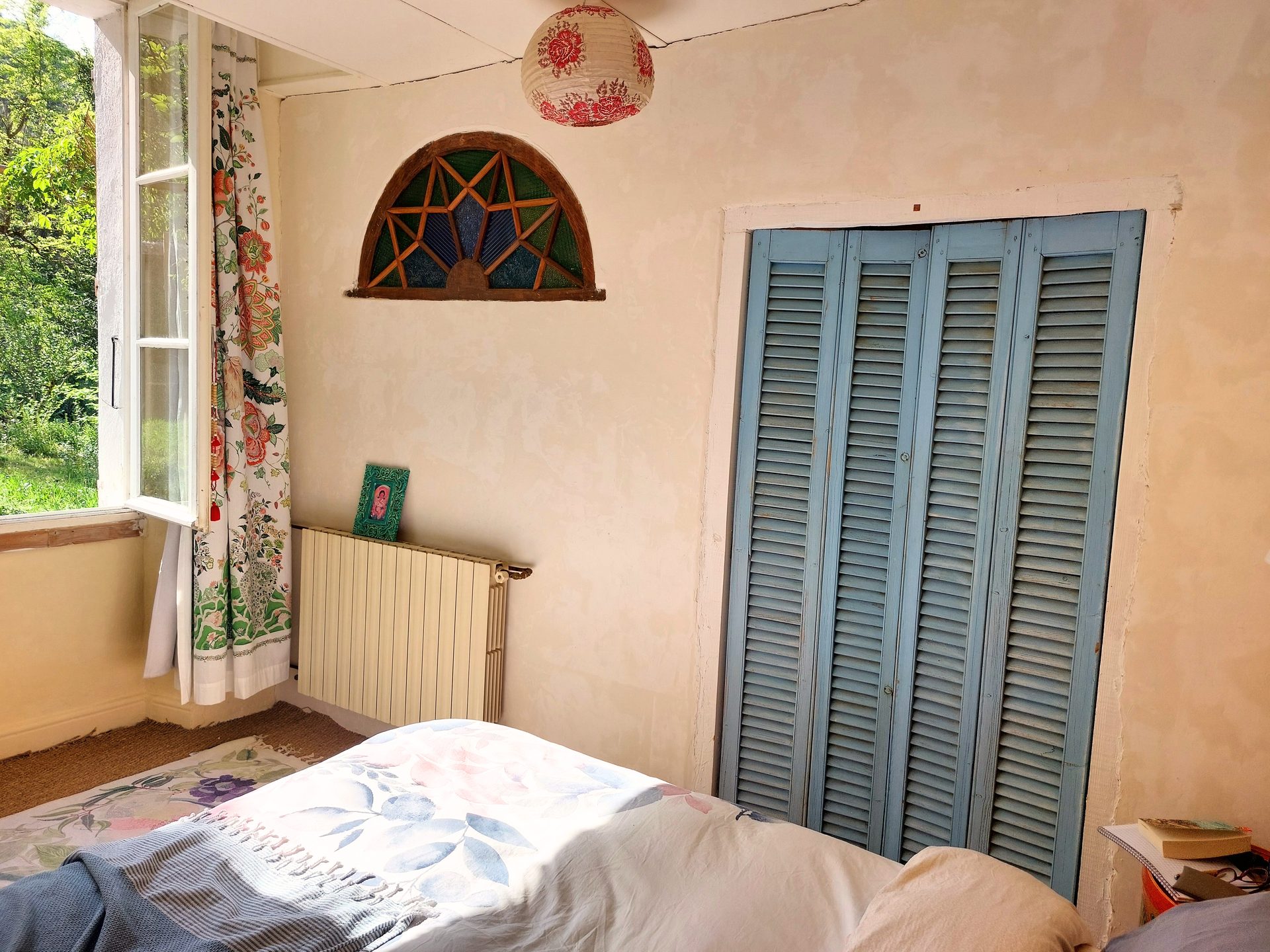 Chambre 1 — autre vue : fenêtre, volets bleus, vitrail